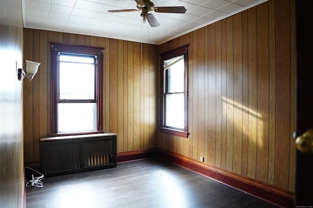 unfurnished room featuring ceiling fan, radiator heating unit, and dark hardwood / wood-style floors