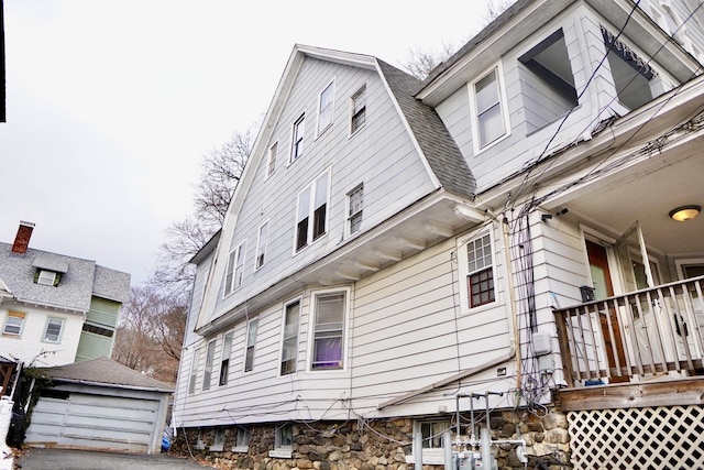 view of side of home featuring a garage and an outdoor structure