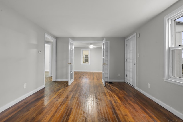 empty room with dark wood-type flooring and french doors