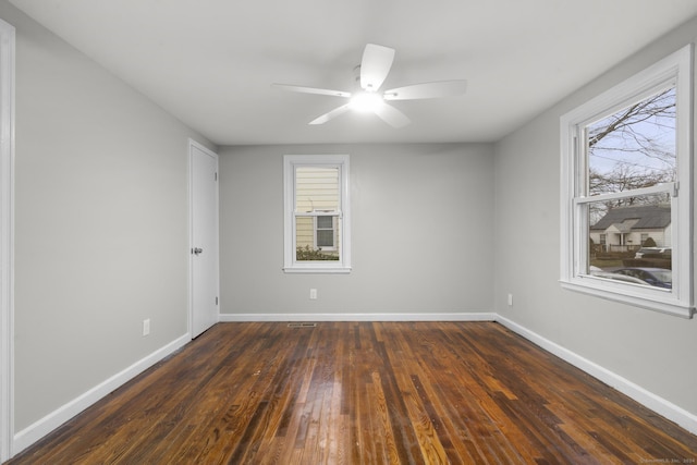 empty room with dark hardwood / wood-style flooring and ceiling fan