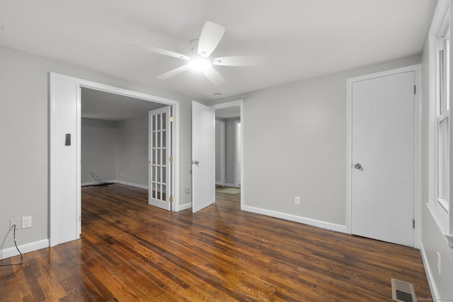 empty room with french doors, dark hardwood / wood-style flooring, and ceiling fan