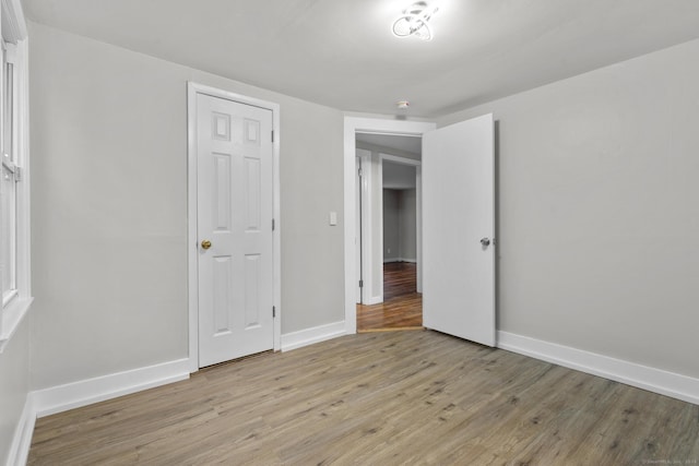 unfurnished bedroom with light wood-type flooring and a closet