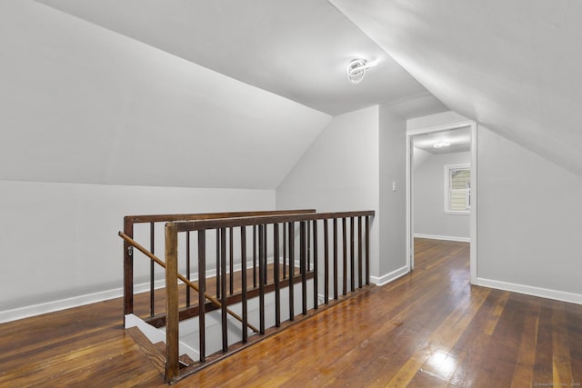 additional living space featuring dark wood-type flooring and lofted ceiling