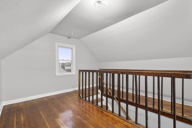 bonus room with vaulted ceiling and dark hardwood / wood-style floors