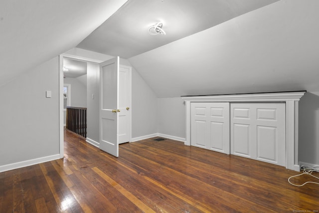 additional living space with dark hardwood / wood-style flooring and lofted ceiling