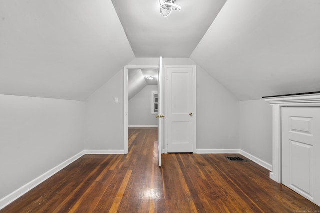 bonus room with vaulted ceiling and dark wood-type flooring