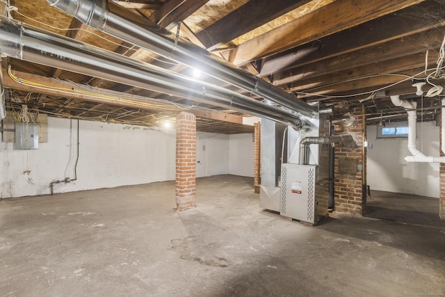 basement featuring electric panel and heating unit