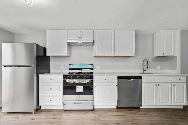 kitchen with sink, white cabinets, stainless steel appliances, and wood-type flooring