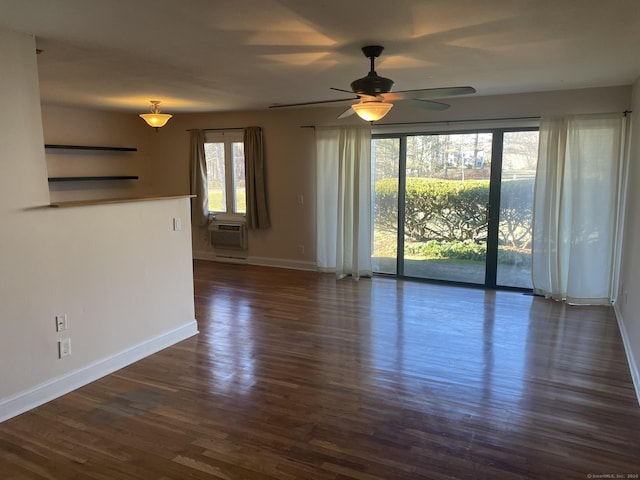 spare room with a wall mounted air conditioner, dark hardwood / wood-style flooring, and ceiling fan