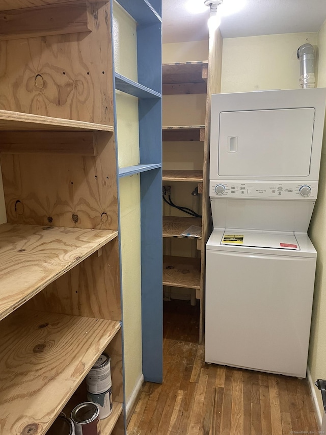 washroom with wood-type flooring and stacked washer / dryer