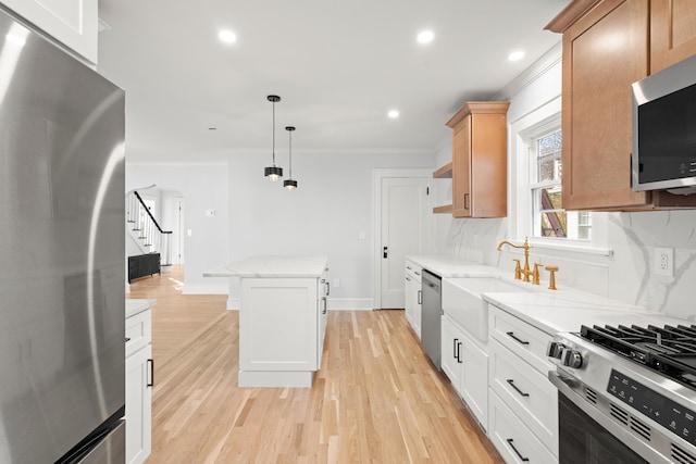 kitchen with a center island, backsplash, white cabinets, decorative light fixtures, and stainless steel appliances