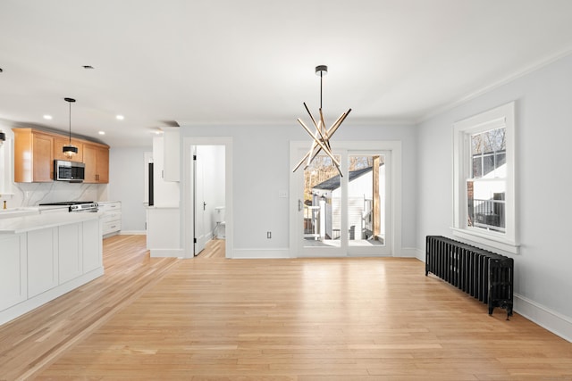 unfurnished dining area with a chandelier, crown molding, radiator, and light hardwood / wood-style flooring