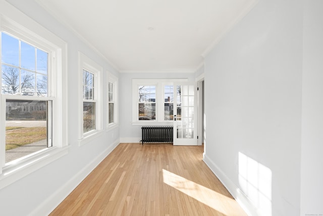 unfurnished sunroom featuring radiator heating unit and a wealth of natural light