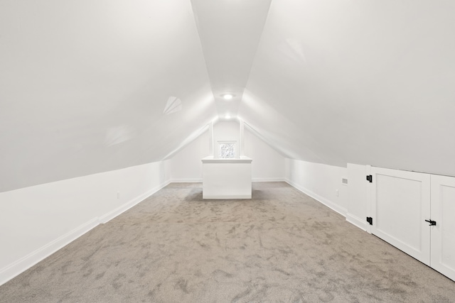 bonus room with light carpet and vaulted ceiling