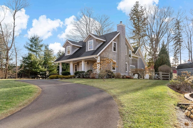 cape cod house with covered porch and a front lawn