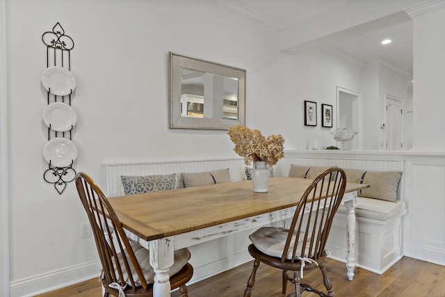 dining room featuring hardwood / wood-style flooring, ornamental molding, and breakfast area