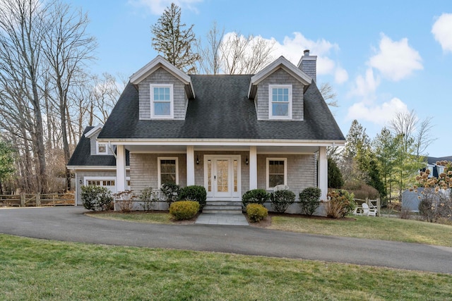 cape cod house featuring a porch and a front yard