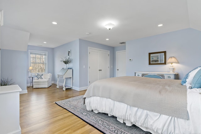 bedroom featuring wood-type flooring, a closet, and vaulted ceiling