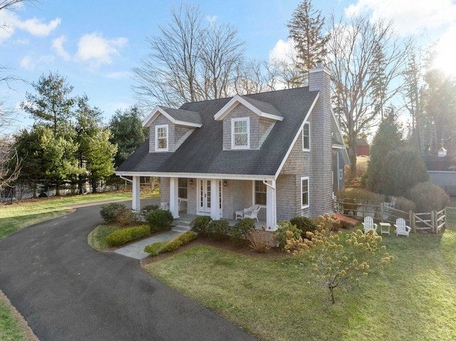 new england style home with a porch and a front lawn