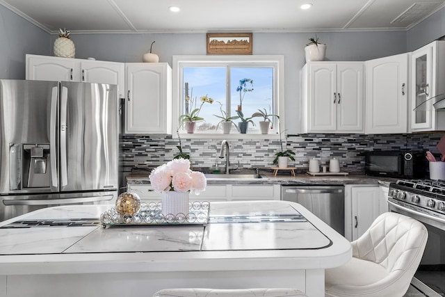 kitchen featuring appliances with stainless steel finishes, backsplash, and white cabinetry