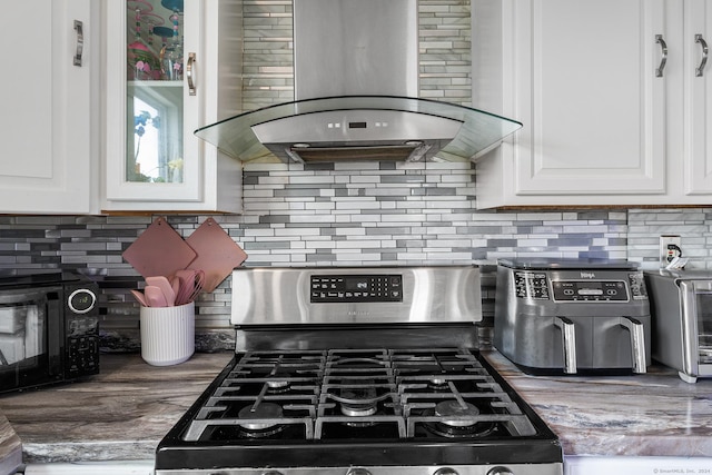 kitchen featuring white cabinetry, stainless steel range with gas cooktop, backsplash, and range hood