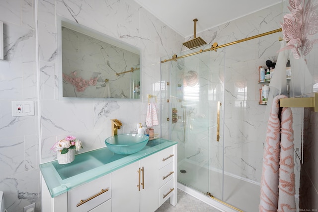 bathroom featuring vanity, a shower with shower door, and tile walls