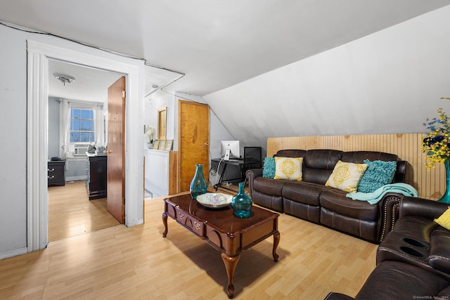 living room with light hardwood / wood-style flooring, cooling unit, and vaulted ceiling