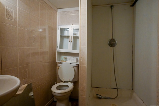 bathroom featuring sink, tile walls, and toilet