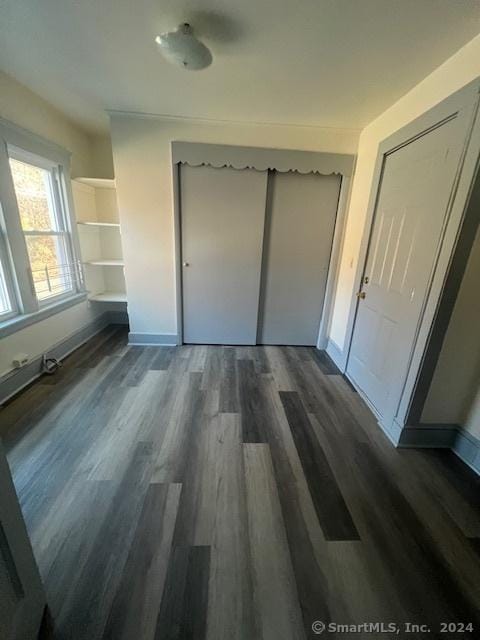 unfurnished bedroom featuring dark hardwood / wood-style flooring and a closet