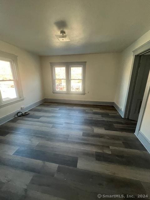 unfurnished dining area with dark wood-type flooring