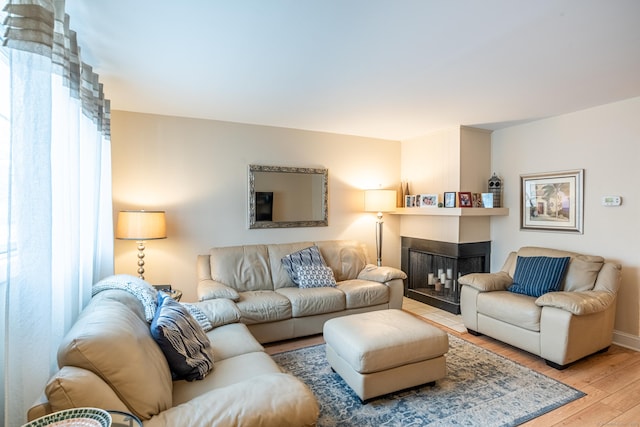 living room featuring light hardwood / wood-style floors and a multi sided fireplace