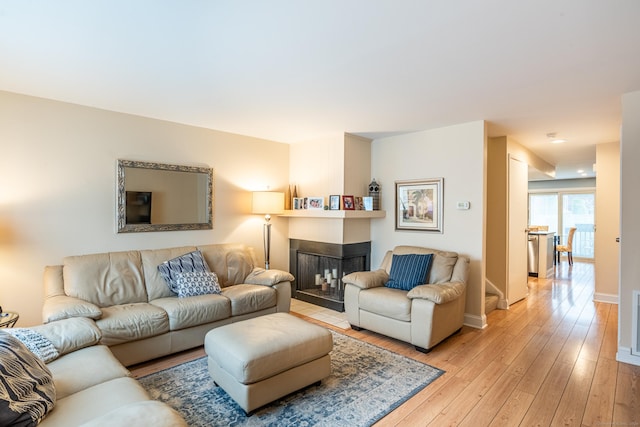 living room with light hardwood / wood-style floors and a tiled fireplace