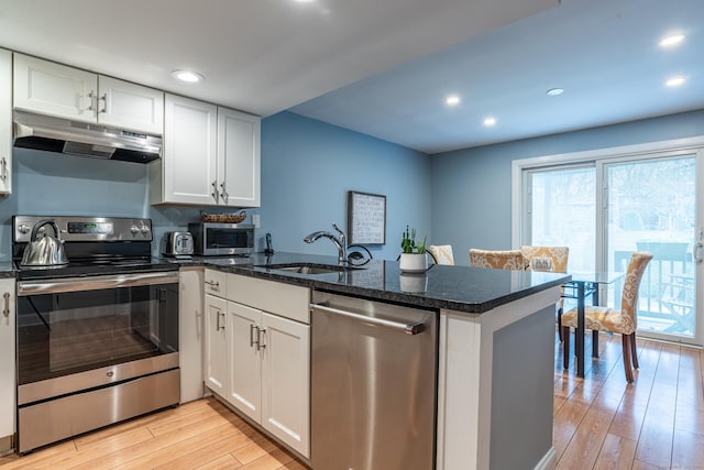 kitchen with kitchen peninsula, stainless steel appliances, and white cabinetry