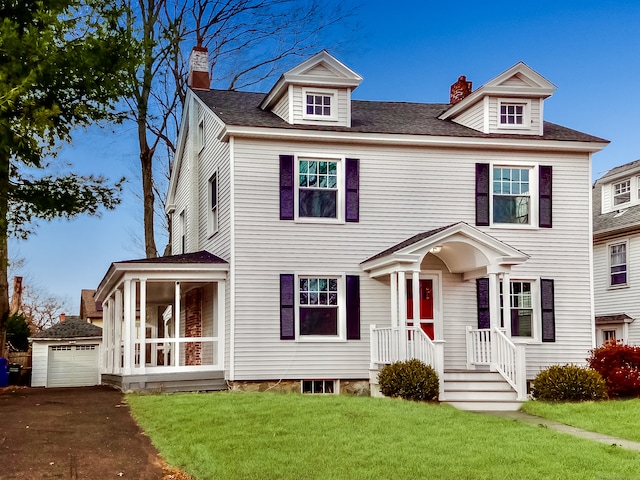 view of front of property with an outbuilding, a front lawn, and a garage