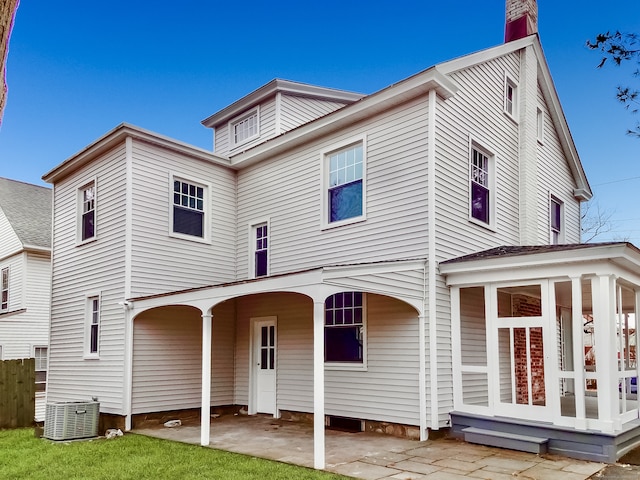 rear view of property with cooling unit and a patio area