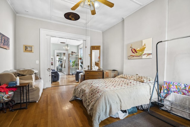 bedroom with ceiling fan with notable chandelier, wood-type flooring, and crown molding