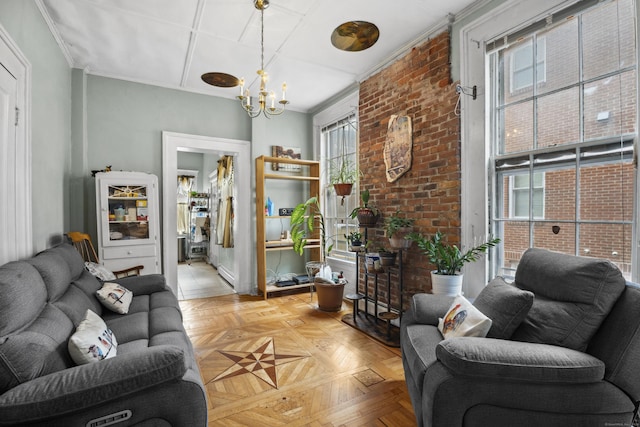 living room featuring crown molding, light parquet flooring, a chandelier, and brick wall