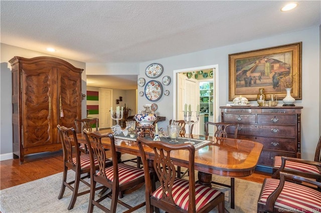 dining space featuring hardwood / wood-style flooring and a textured ceiling