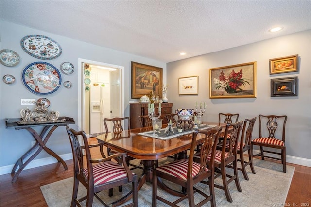 dining room featuring a textured ceiling and hardwood / wood-style flooring