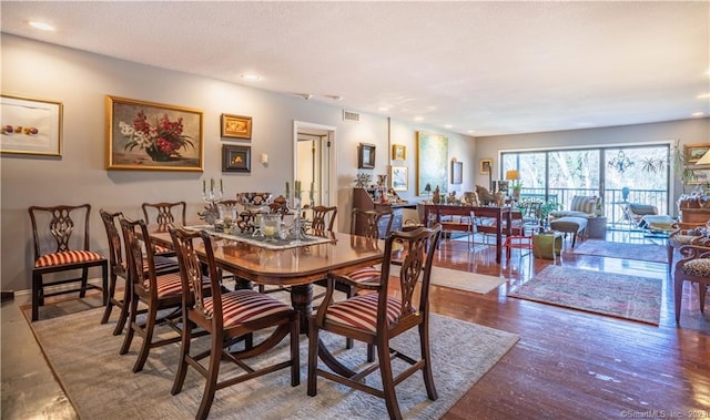 dining area with hardwood / wood-style floors and a textured ceiling