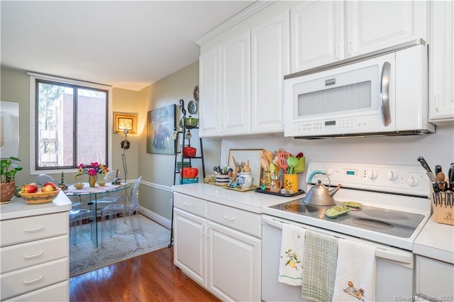 kitchen featuring dark hardwood / wood-style flooring, white appliances, and white cabinetry