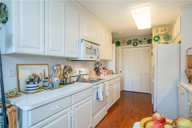 kitchen featuring dark hardwood / wood-style flooring, white cabinets, and white appliances