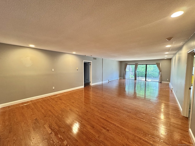 795 Prospect Ave Unit B-5, West Hartford, CT 06105 - empty room with a textured ceiling, wood finished floors, baseboards, recessed lighting, and a baseboard heating unit