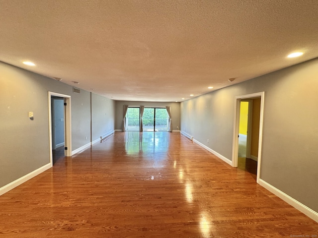 795 Prospect Ave Unit B-5, West Hartford, CT 06105 - spare room with a textured ceiling, wood finished floors, a baseboard heating unit, recessed lighting, and baseboards