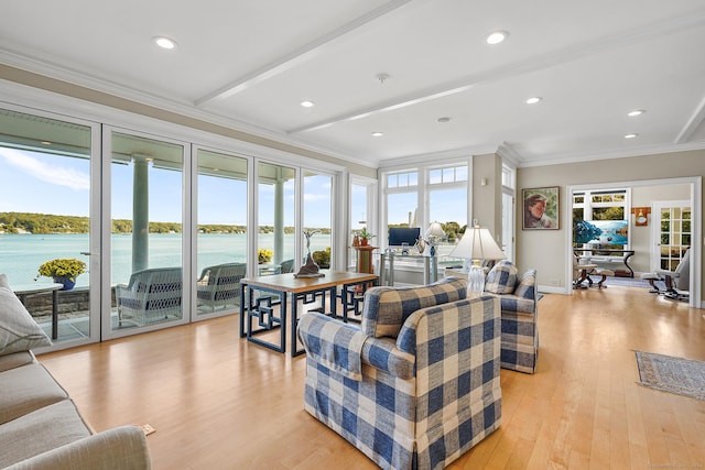 living room with plenty of natural light, light hardwood / wood-style floors, and ornamental molding