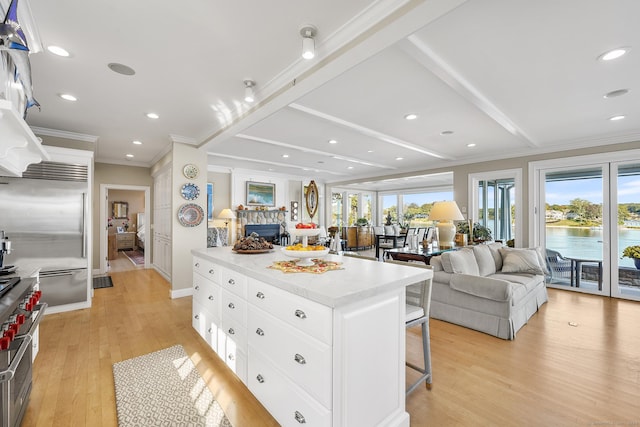 kitchen featuring a center island, white cabinets, a kitchen breakfast bar, light hardwood / wood-style flooring, and high quality fridge