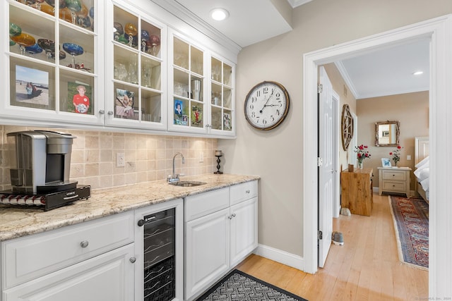 bar featuring light stone counters, sink, light hardwood / wood-style flooring, white cabinets, and wine cooler