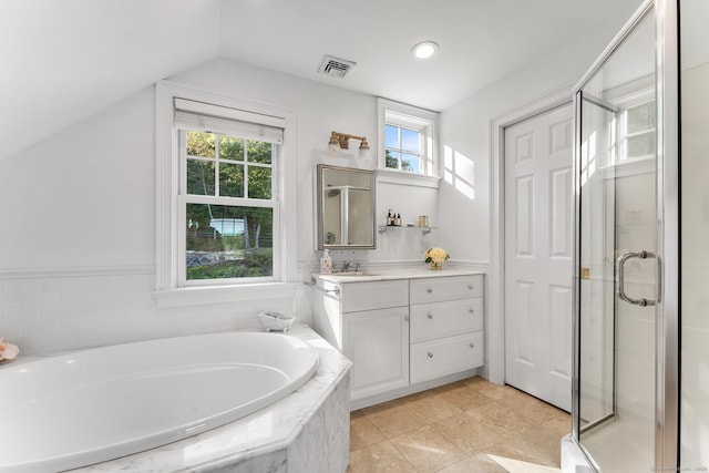 bathroom featuring shower with separate bathtub, vanity, vaulted ceiling, and a wealth of natural light