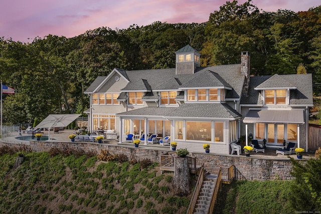 back house at dusk featuring an outdoor hangout area and a patio