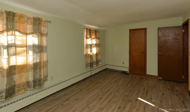 spare room with wood-type flooring and baseboard heating